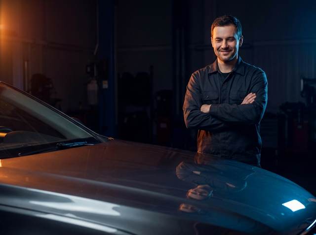 Technician admiring the finished, dent-free panel